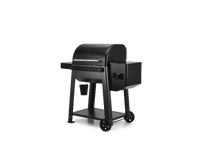 A black pellet grill with a side burner and wheels, shown from a three-quarter angle on a solid white background.